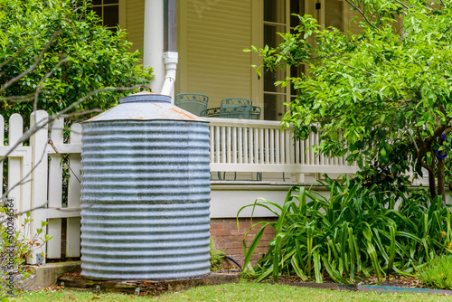 Sheet metal rain barrel next to porch on front of house in New Orleans, Louisiana, USA photo