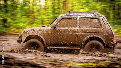 Dirty off-road car at a speed over dirt. photo