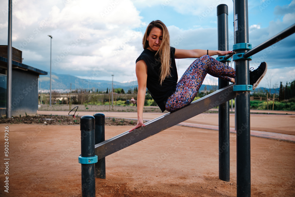 Φωτογραφία Young blonde woman performing calisthenics exercises in an urban park