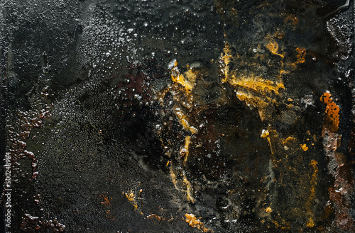 Texture, background, top view of a black tray smeared in fat, after cooking a meat dish. Food photography, abstract.