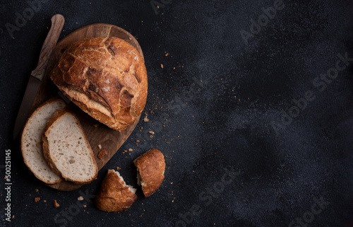 Fotobehang Loaf of bread freshly baked and cut on dark background