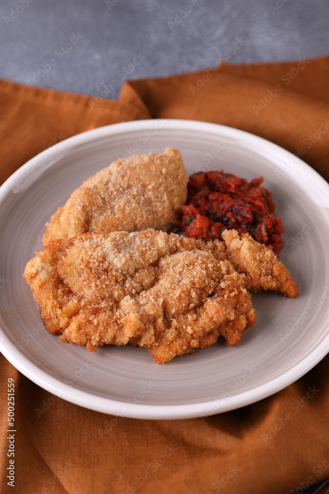 Breaded chicken cotoletta with tomato sauce Breaded chicken cotoletta with tomato sauce
