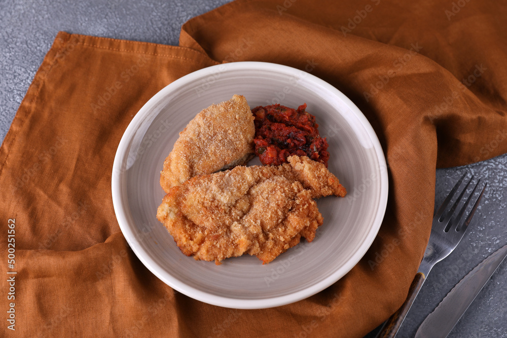 Breaded chicken cotoletta with tomato sauce Breaded chicken cotoletta with tomato sauce