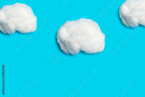 Nubes esponjosas hechas de algodón sobre un fondo celeste turquesa liso y aislado. Vista de frente y de cerca. Copy space photo