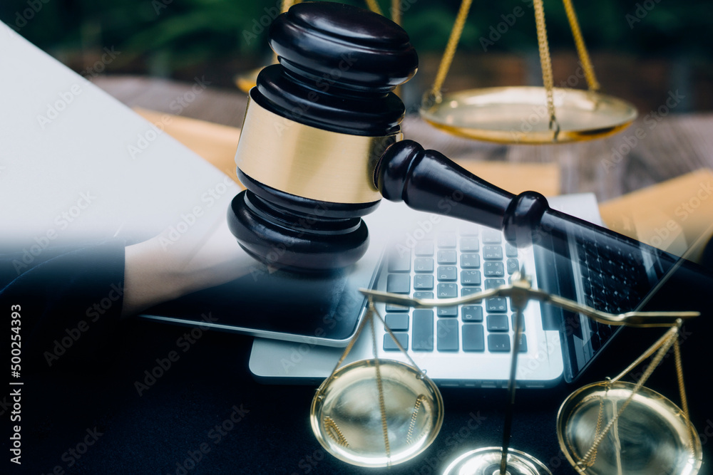 Obraz premium Justice and Law concept. Legal counsel presents to the client a signed contract with gavel and legal law or legal having team meeting at law firm in background