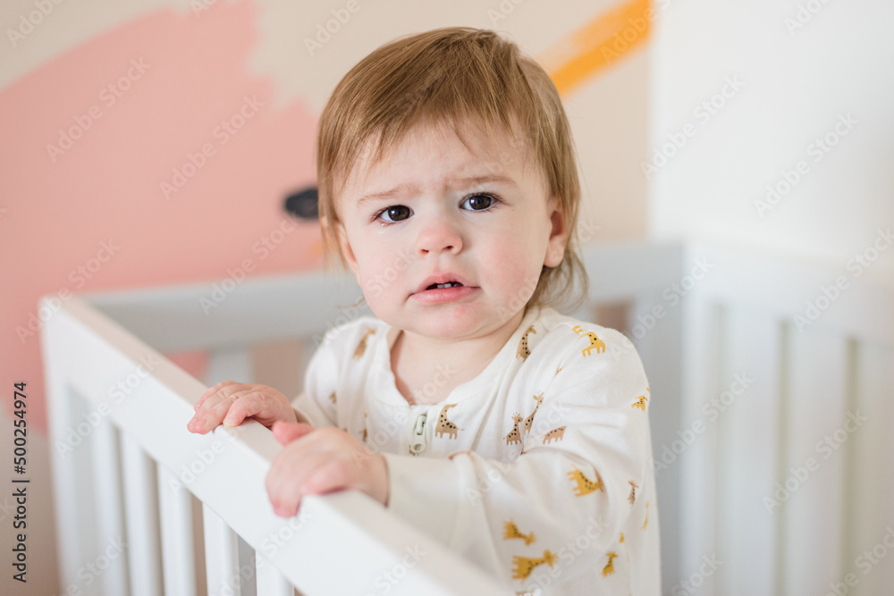 Sleepy baby girl standing in bed in the morning Sleepy baby girl standing in bed in the morning