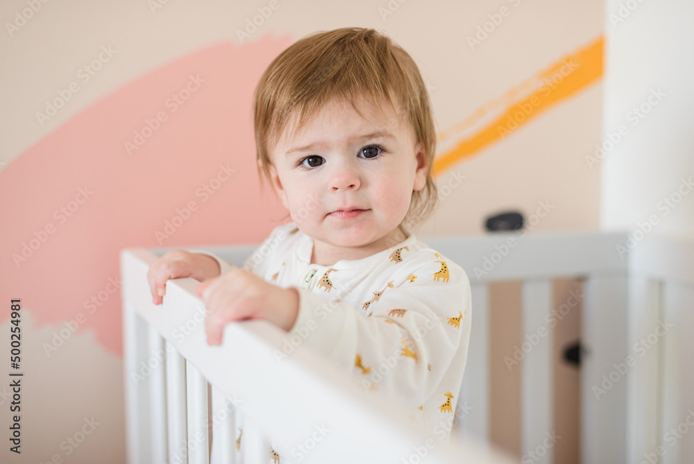 Sleepy baby girl standing in bed in the morning Sleepy baby girl standing in bed in the morning