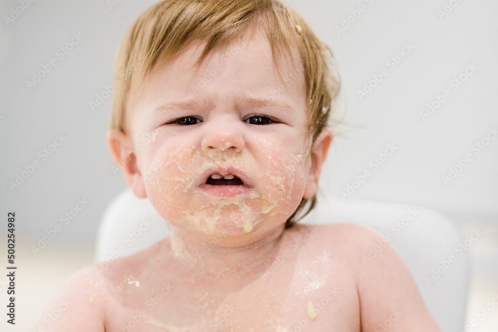 Smeary baby girl eating food with hands Smeary baby girl eating food with hands