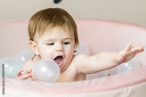 baby playing with balls in ball pool at home