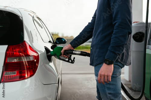 Anonymous man refilling vehicle tank at petrol station photo