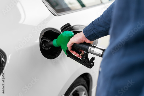 Anonymous man refilling vehicle tank at petrol station photo