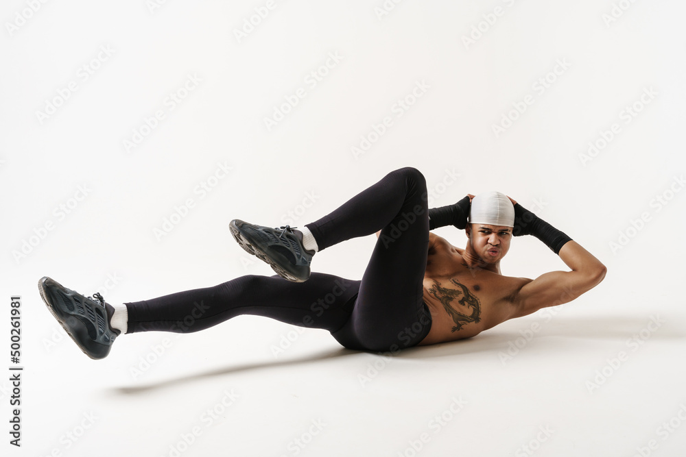 © Drobot Dean - Young shirtless sportsman doing exercise while working out