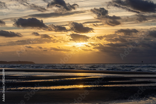 Fantastic view of the dark overcast sky. Dramatic and picturesque golden evening sunset scene over the sea. Storm clouds, storm passing over sea, dramatic clouds after storm at sunset. Defocused. High