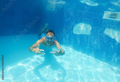 Underwater man close up portrait in swimming pool.