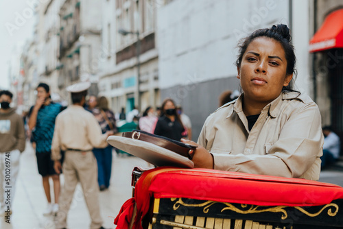 Hispanic woman working as a musical organ grinder in Latin America 