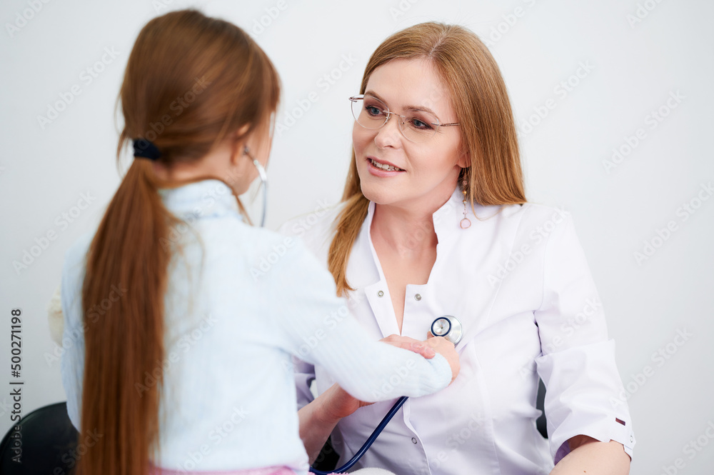 Little girl patient checking heartbeats female doctor in hospital by stethoscope Little girl patient checking heartbeats female doctor in hospital by stethoscope