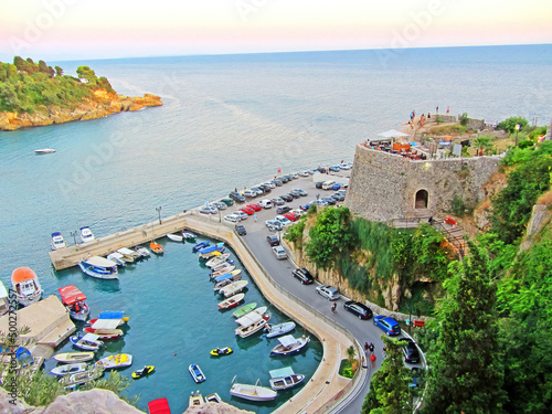 Resort town on the coast of Montenegro. Cove with boats on the Adriatic Sea, a small tourist town with beaches. Tourist trips, swimming in the sea with boats and buoys. Sanatoria casino and bouzas photo