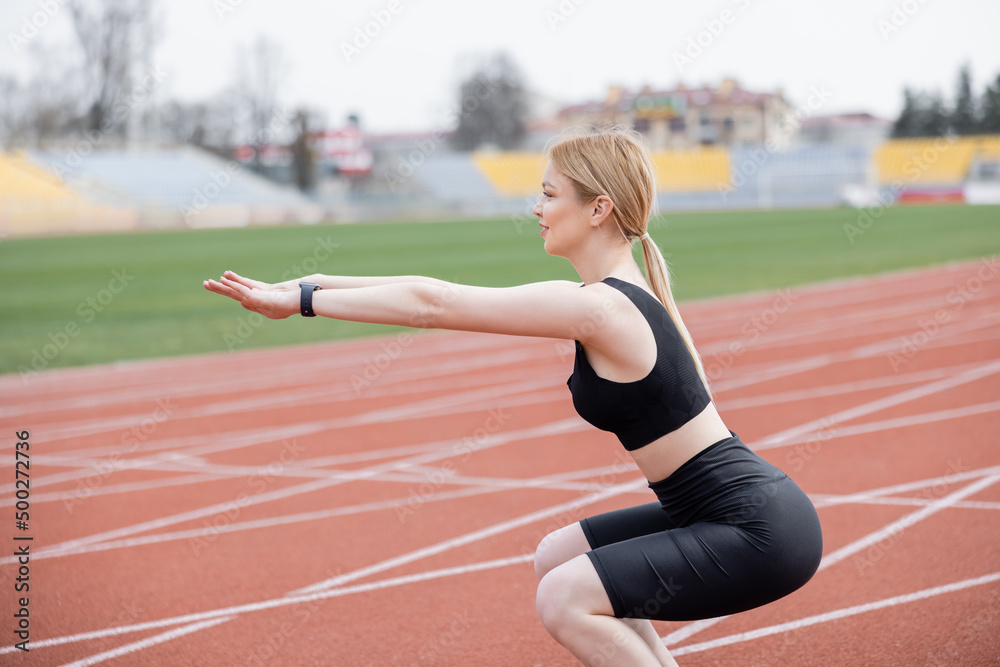 side view of sportswoman doing sit ups with outstretched hands.