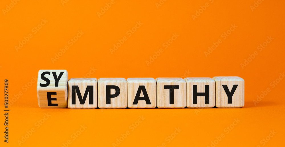 Sympathy or empathy symbol. Turned wooden cubes and changed the concept word Empathy to Sympathy. Beautiful orange table orange background. Copy space. Psychological sympathy or empathy concept. - obrazy, fototapety, plakaty 