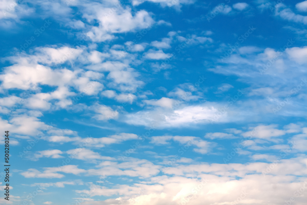 Defocus blue sky background with tiny white clouds. Panorama blue sky background with clouds. Abstract blurred piece background. Summer sky. Out of focus