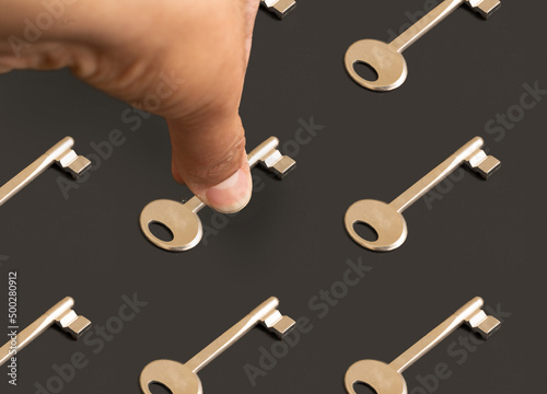 Close up photo of hand picking one of the keys. Concept of lifetime decision treshold and skillset. photo