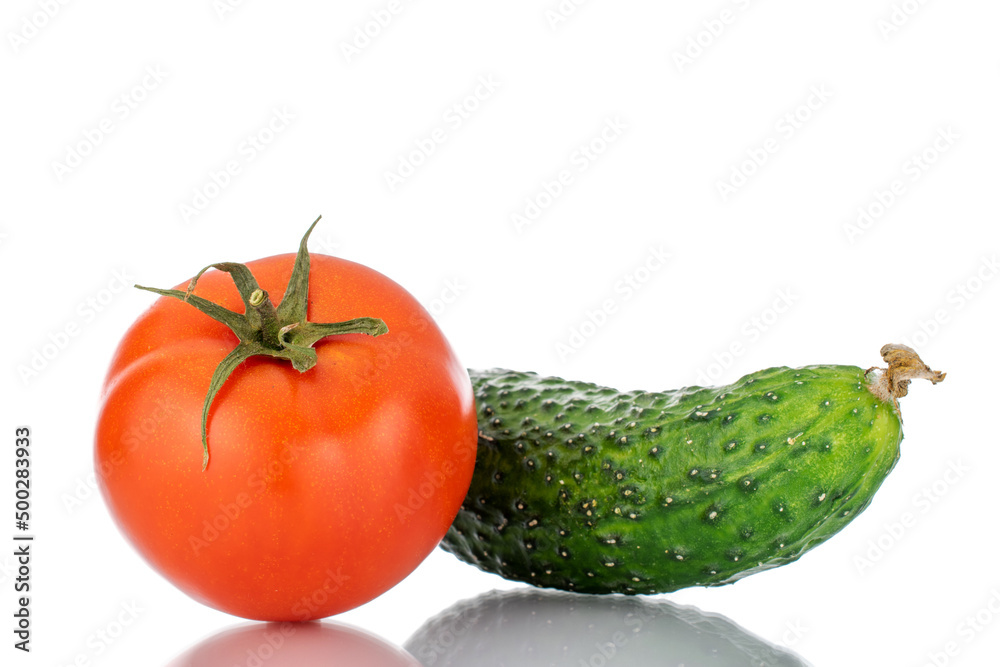 One ripe tomato and cucumber, macro, isolated on white background. One ripe tomato and cucumber, macro, isolated on white background.