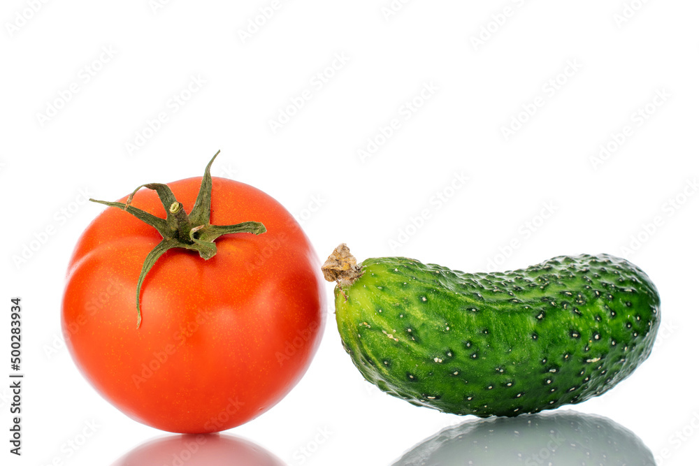 One ripe tomato and cucumber, macro, isolated on white background. One ripe tomato and cucumber, macro, isolated on white background.