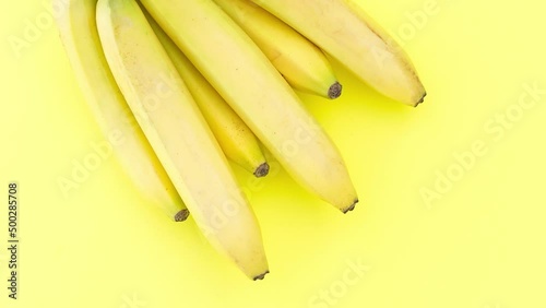 Fresh ripe bananas on a yellow background