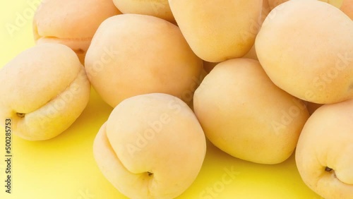Ripe fresh apricots on a yellow background