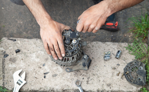 Man repairs car alternator. Technology. Industry photo