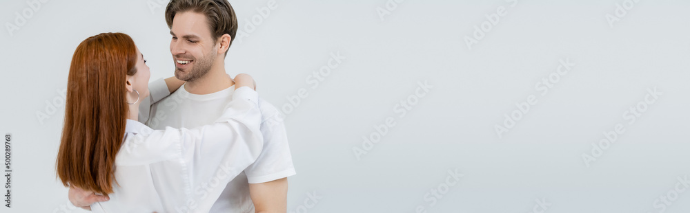 Young woman in shirt embracing smiling boyfriend isolated on white, banner. Young woman in shirt embracing smiling boyfriend isolated on white, banner.