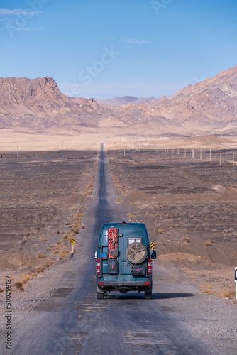 4x4 camper van photograph taken from behind on a dusty desert road in Iran photo