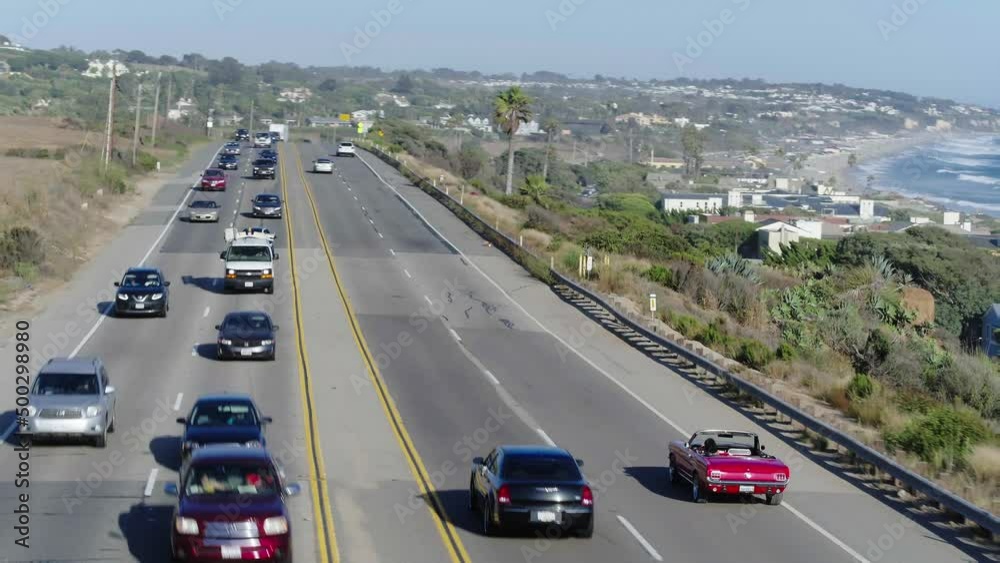 Aerial Forward Panning Shot Of Cars Moving On Road By Beach, Drone Flying Over Landscape On Sunny Day - Malibu, California