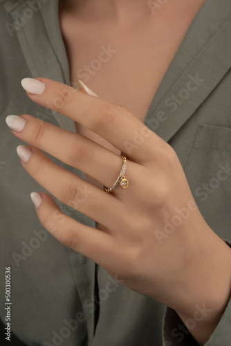 Beautiful lady's hand. woman wearing a white blouse and a diamond ring on her finger. © Oguz