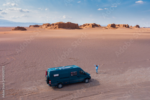 Campervan in the middle of desert at sunset