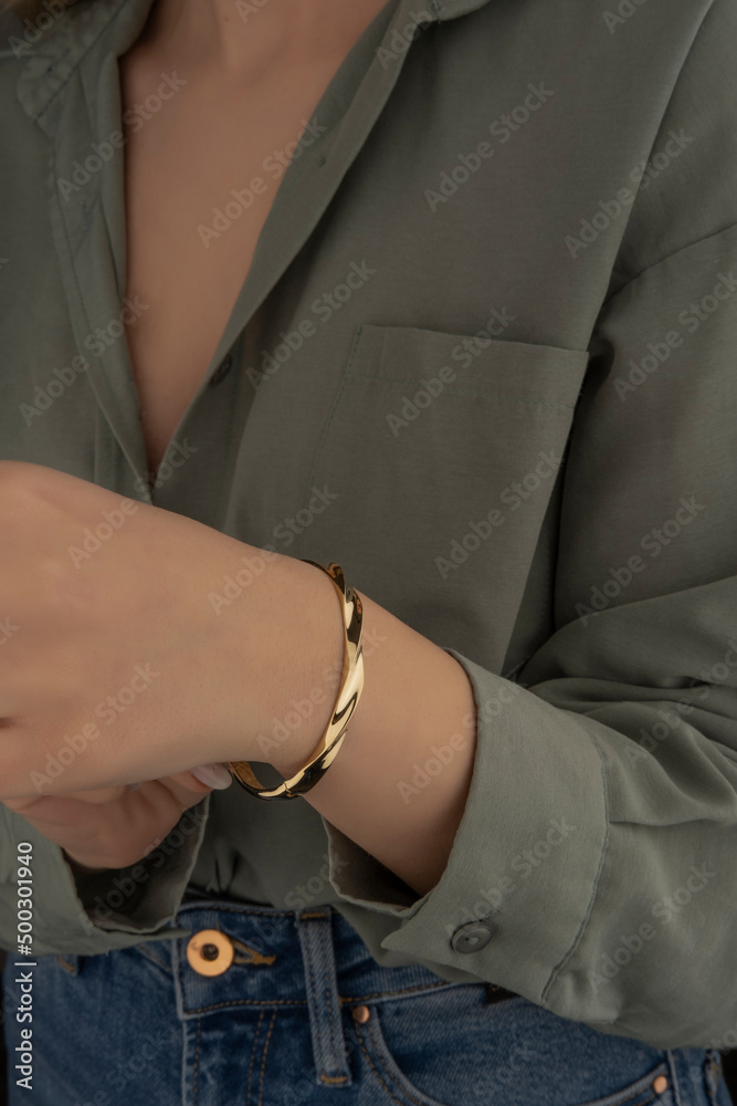 women's gold bracelet on the girl's hand, women's accessories, jewelry, gold bracelet with stones, women's jewelry, a girl with a bracelet on her arm, a bracelet with stones