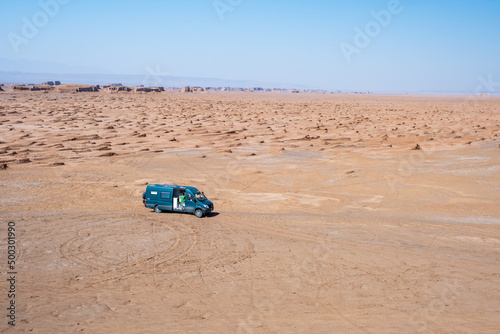 Woman in the middle of the desert in her campervan with a green shirt