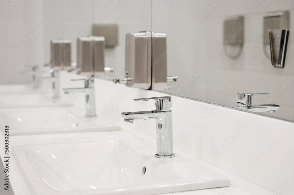 interior shot of a modern bathroom in the foreground the washbasin with a steel tap interior shot of a modern bathroom in the foreground the washbasin with a steel tap