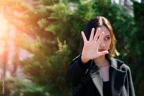 female palm close up raised in prohibiting gesture. shows stop sign prohibition symbol keeps palm forward to camera. Place for text, copyspace.