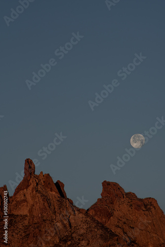 Full moon setting over Tetakawi Mountain, a majestic landmark and popular spot for hiking in San Carlos, Sonora, Mexico. photo