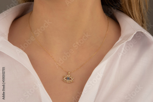 Beautiful model brunette curly hair woman on modern gold metal necklace chain