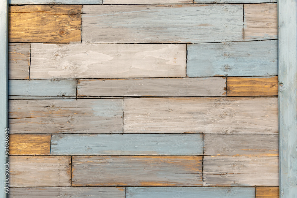 Naklejka premium A patchwork of recycled wooden squares making up a verticle wall. 