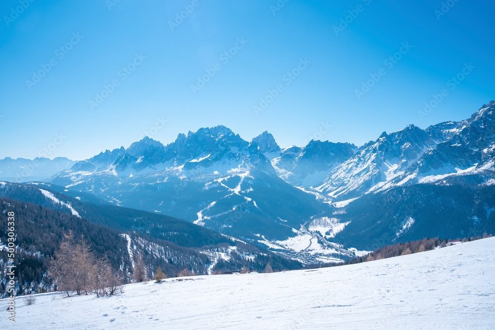 Panoramic view of majestic kronplatz mountain range against blue sky. Scenic snow covered landscape during winter. Idyllic view of alpine region.