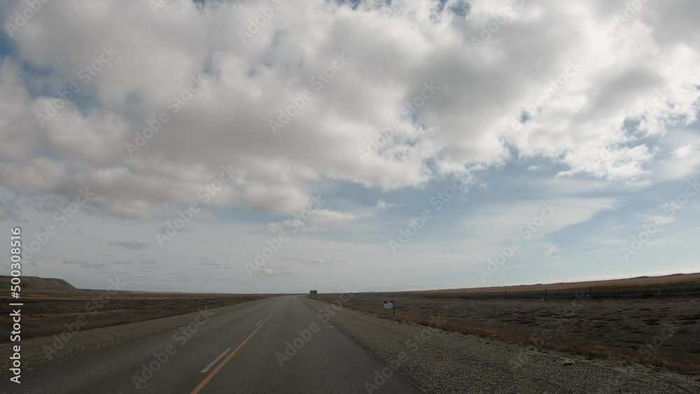Road trip. Point of view of a car driving along the rural highway across the yellow meadow. View of the horizon and beautiful blue sky with clouds. Road trip. Point of view of a car driving along the rural highway across the yellow meadow. View of the horizon and beautiful blue sky with clouds.