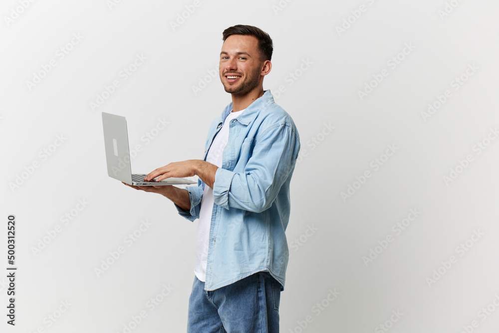 Happy tanned handsome man in casual basic t-shirt chatting with friends by laptop look at camera posing isolated on over white studio background. Copy space Banner Mockup. Gadgets lifestyle concept Happy tanned handsome man in casual basic t-shirt chatting with friends by laptop look at camera posing isolated on over white studio background. Copy space Banner Mockup. Gadgets lifestyle concept
