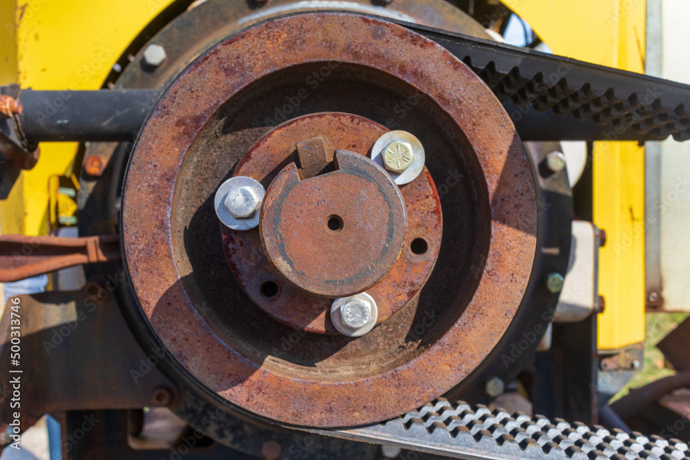 Old rusty metal construction machine belt drive wheel 
