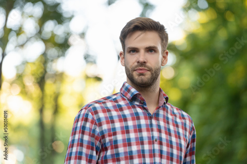 young man in checkered shirt outdoor, copy space