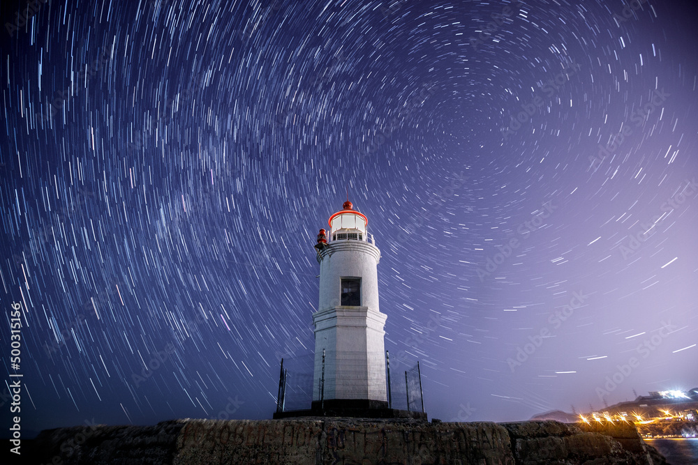 Lighthouse Tokarevsky in Vladivostok at night. Starry against the backdrop of a beautiful lighthouse.