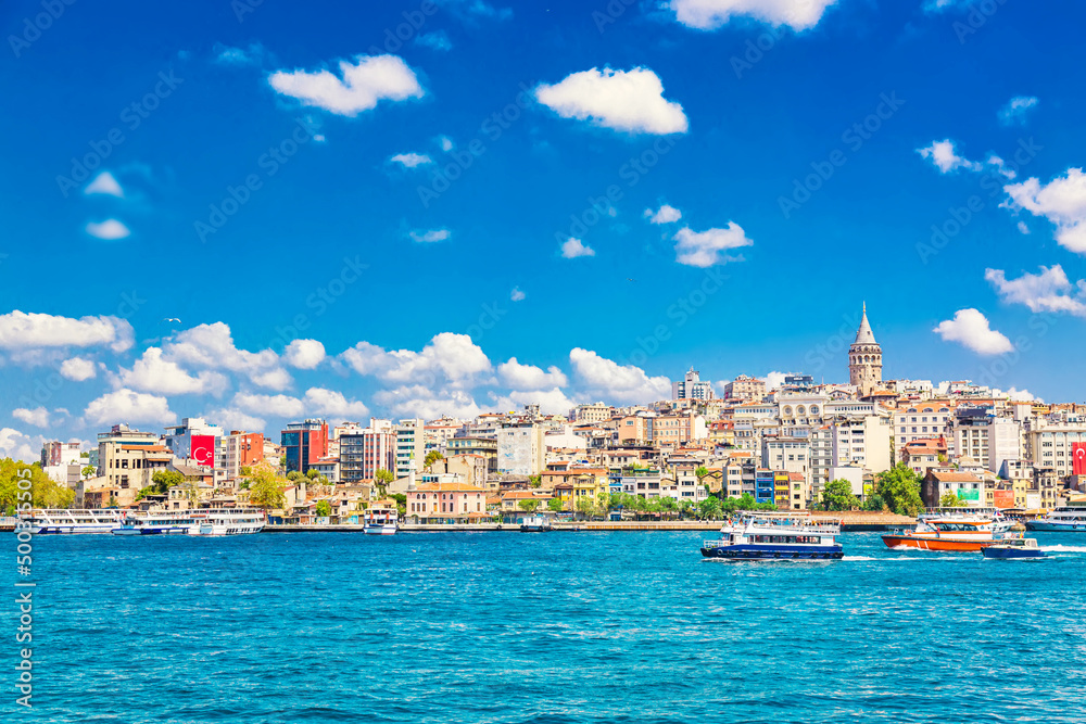 Beyoglu historic district and Galata tower medieval landmark with sightseeing ships. Istanbul, Turkey
