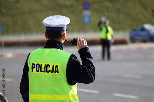  Policjant policji drogowej podczas kierowania ruchem z lizakiem do zatrzymywania pojazdów.